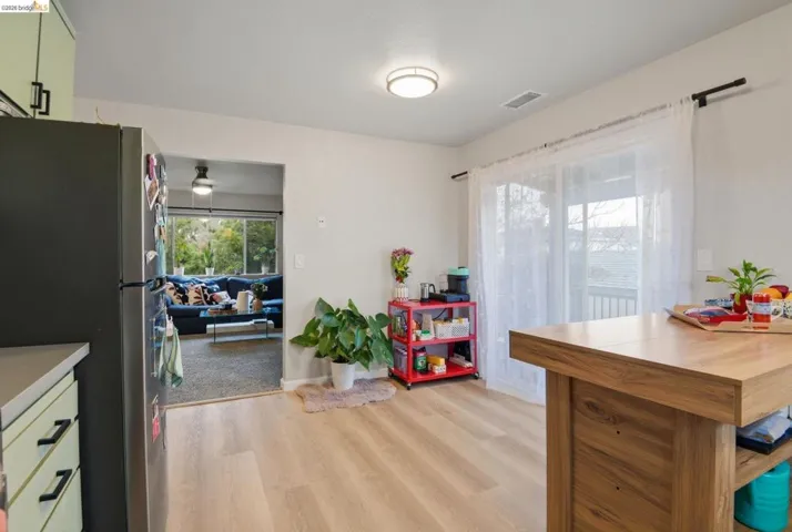 Kitchen featuring freestanding refrigerator, light wood-style floors, and light countertops
