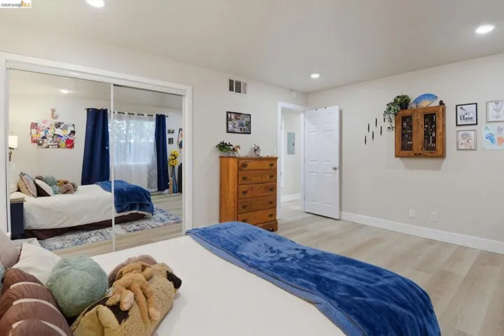 Bedroom with light wood-style floors, recessed lighting, and a closet