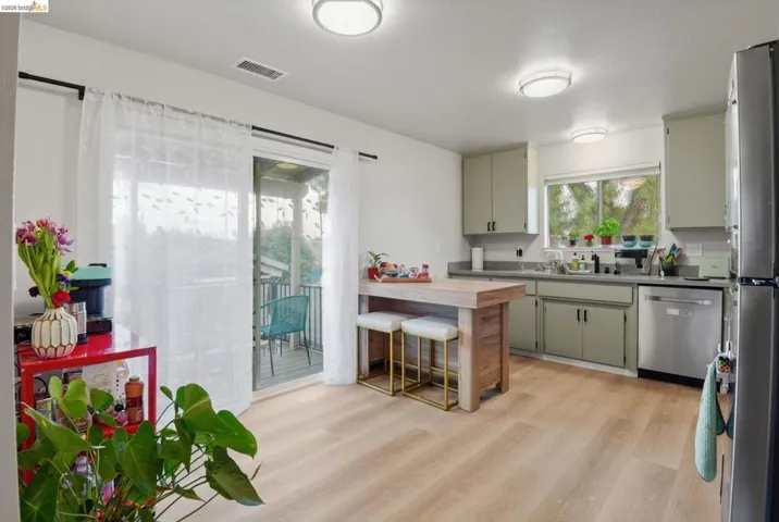 Kitchen featuring a breakfast bar area, a peninsula, light countertops, light wood-style flooring, and stainless steel appliances