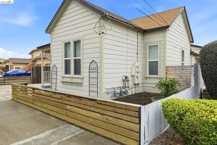Bungalow-style home featuring a fenced front yard and roof with shingles