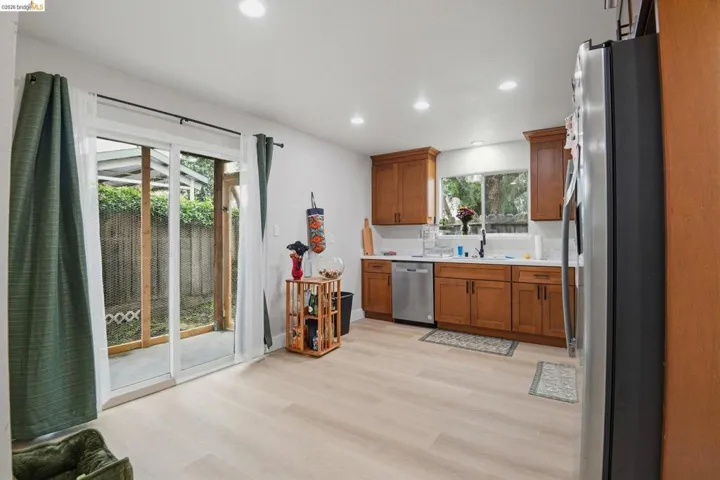 Kitchen featuring wood finish cabinetry, light countertops, stainless steel appliances, light wood-type flooring, and recessed lighting