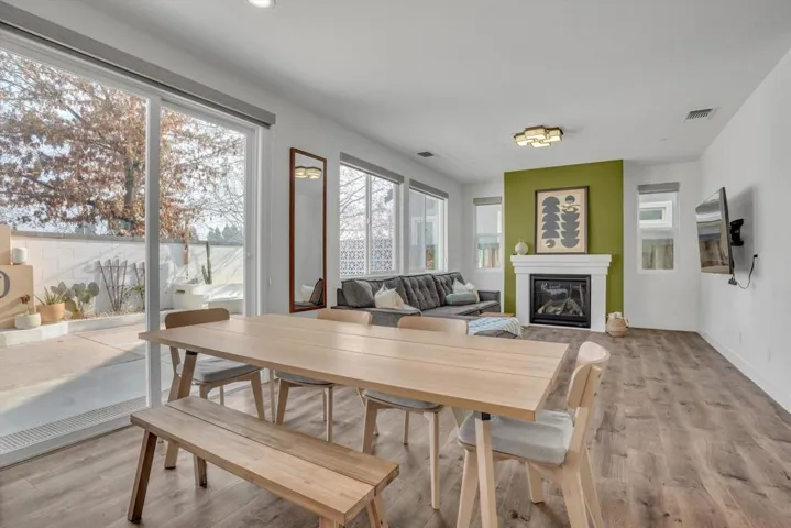 Dining space featuring a glass covered fireplace and light wood-style floors