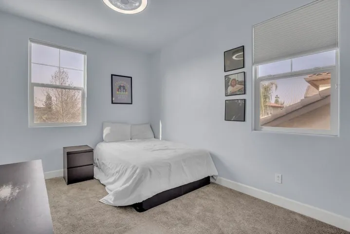 Bedroom with baseboards and light carpet