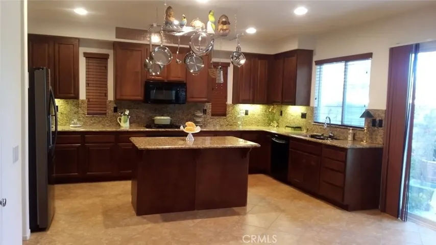 Beautiful Chef's Kitchen with rich, warm dark cabinetry. Seating at island.