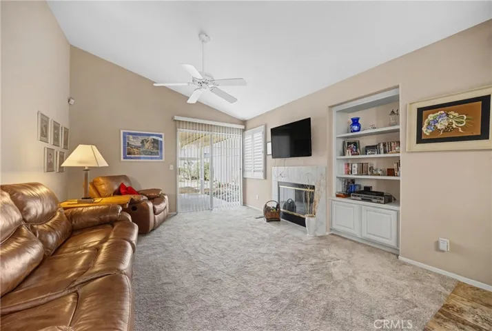 Comfortable Family Room With Fireplace And Built-In Media Shelving. cool ceiling fan and handy built in unit.