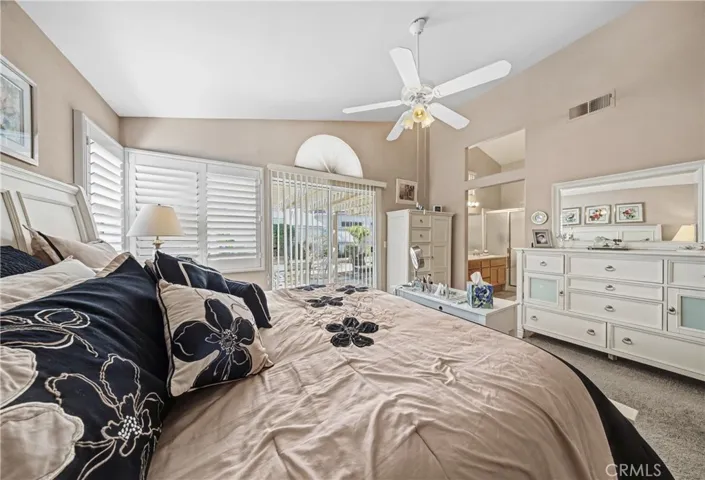 Spacious Primary Bedroom With Ceiling Fan And Natural Light. Window covering and shutters