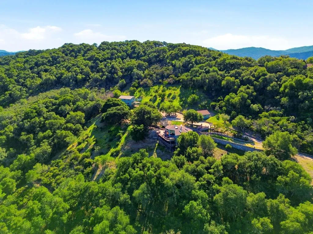 The property is flanked with trees and greenery while being situated in a Firewise community.