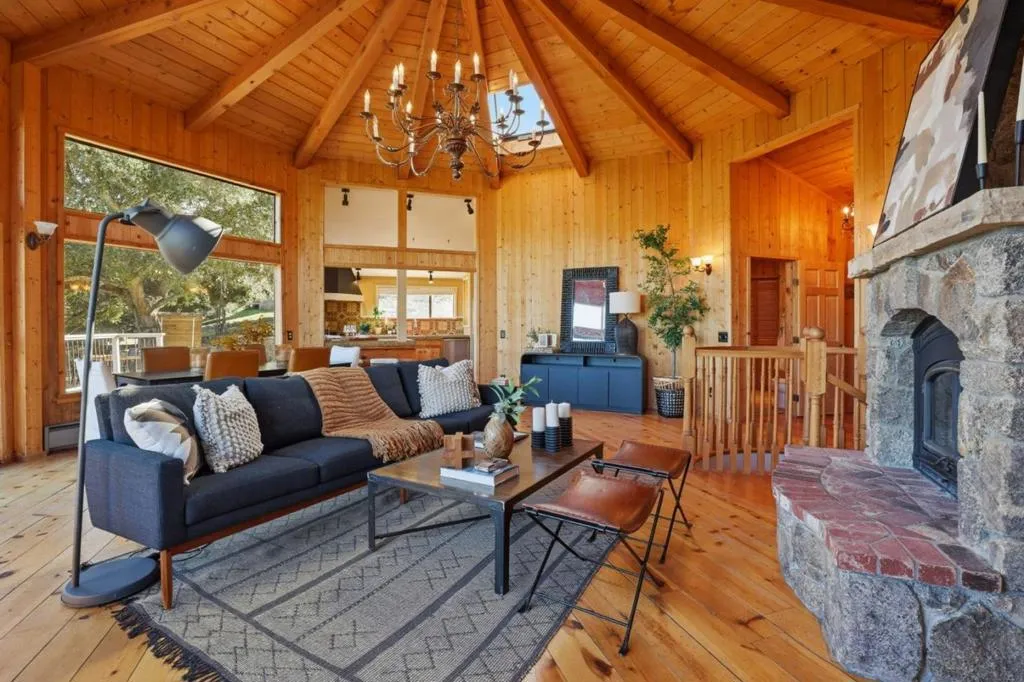Main house living room on the main level; stone fireplace