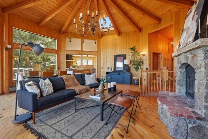 Main house living room on the main level; stone fireplace