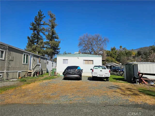 Back of home with additional parking and storage shed