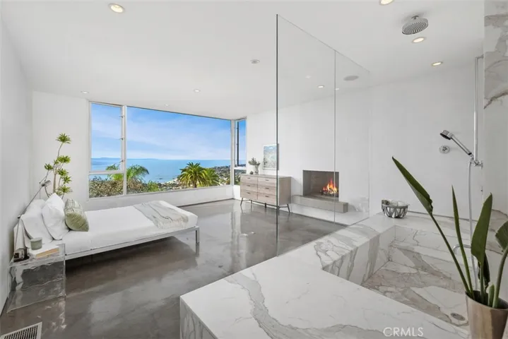 Primary bedroom has more of the incredible view to enjoy, cozy fireplace.
