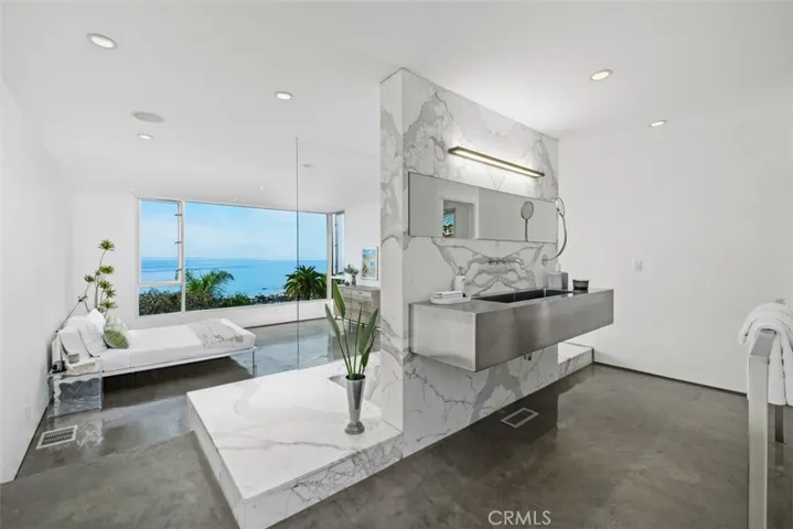 Primary bath has stainless sink, marble tub/shower and new toilet.