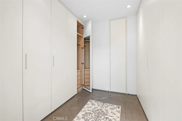 Separate room for the primary bedroom's walk in closet that has high end built-ins, mirrors on most doors and lots of hanging space.
