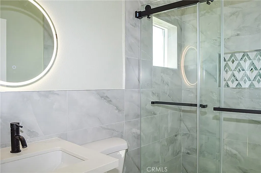 Unit 2 - Main Suite Bath with glass-enclosed shower, lighted mirror and even a view from the shower