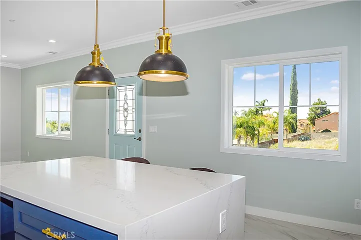 Unit 2 - Well-appointed kitchen with range, hood, dishwasher, quartz counters, waterfall edge on island, and custom lighting