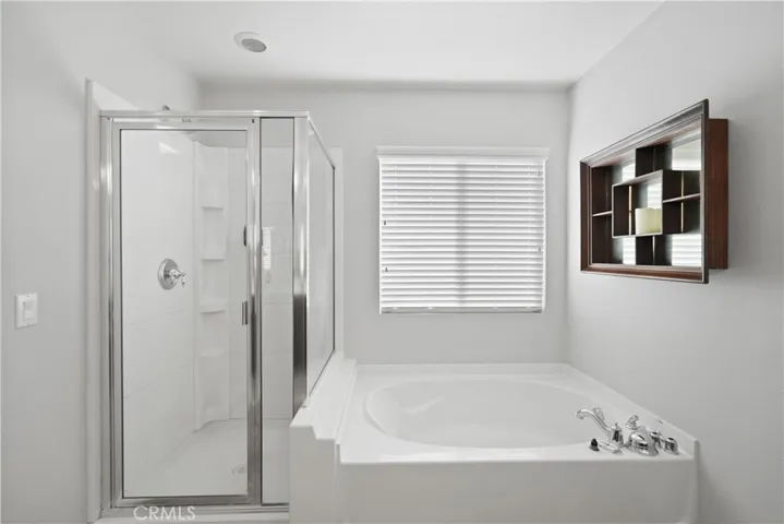 Deep soaking tub and separate glass-enclosed shower.