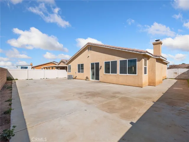 The backyard is fully enclosed with durable vinyl fencing and features an expansive concrete patio area- providing low-maintenance outdoor space ideal for entertaining, gatherings, or future patio cover installation.
