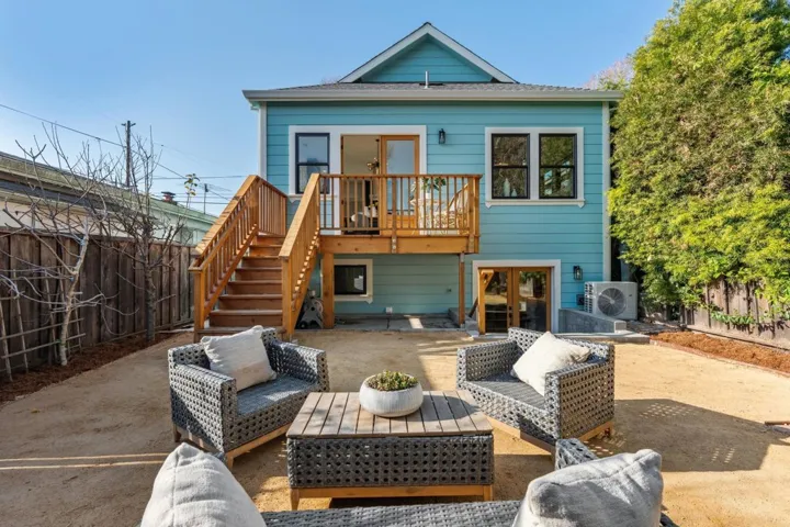 Back of house with outdoor seating, a patio area, a fenced backyard, and a wooden deck