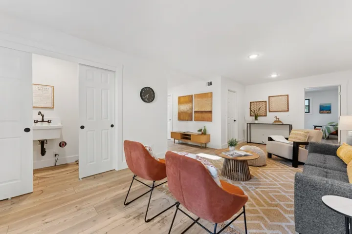 Living area with light wood-type flooring and recessed lighting
