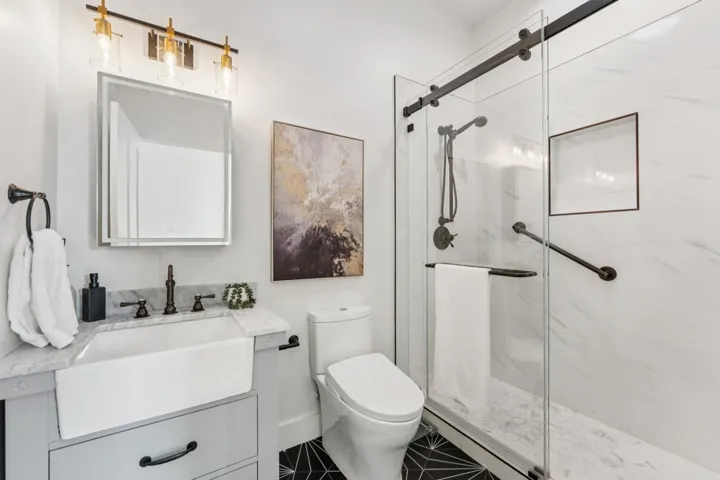 Full bathroom featuring vanity and a marble finish shower