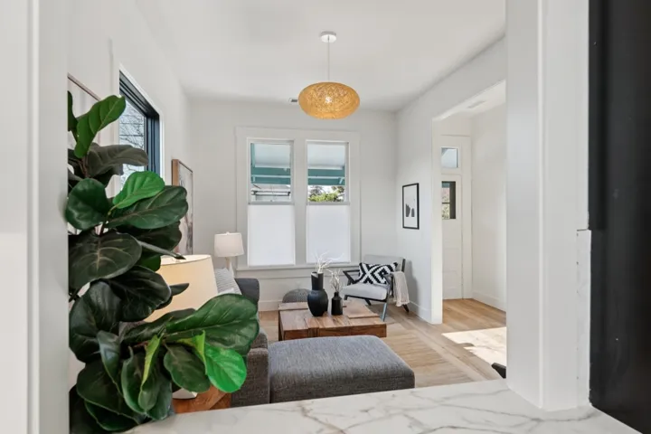 Living area with light wood-style floors and healthy amount of natural light