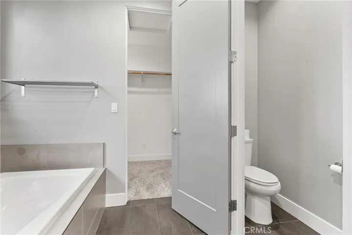 Primary bath with walk in closet. Toilet privacy door.