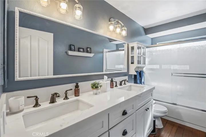 Spacious and Updated hall bathroom with dual sinks and quartz counter over shaker cabinet.