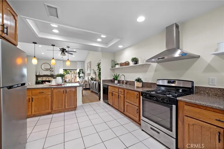 Granite counters, open shelving, beautiful cabinetry, tile floor, recessed lighting