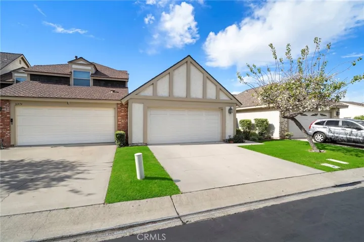 Wide driveway to 2-car garage and manicured landscaping