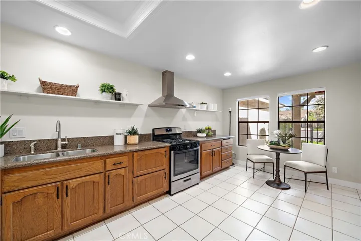 Chef's dream kitchen has recessed lighting, tile floor, granite counters, stainless appliances, eat-in breakfast nook