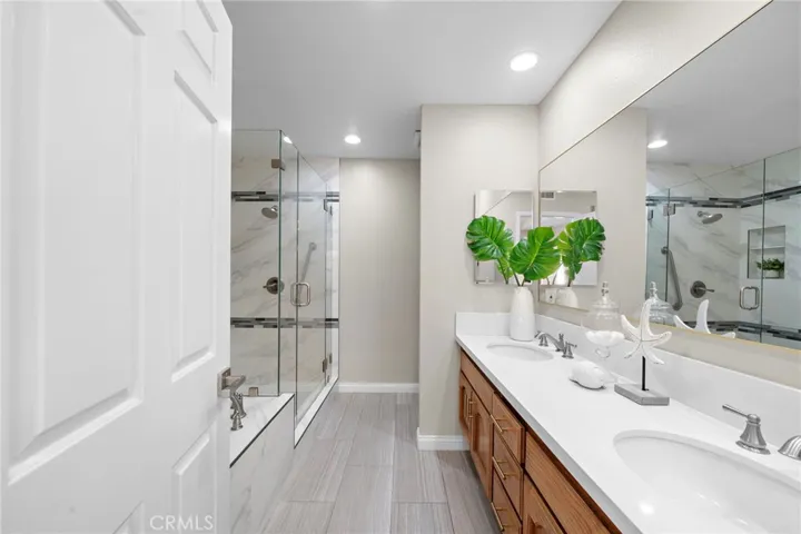 Luxurious spa-style primary bathroom with dual sinks, soaking tub, separate shower
