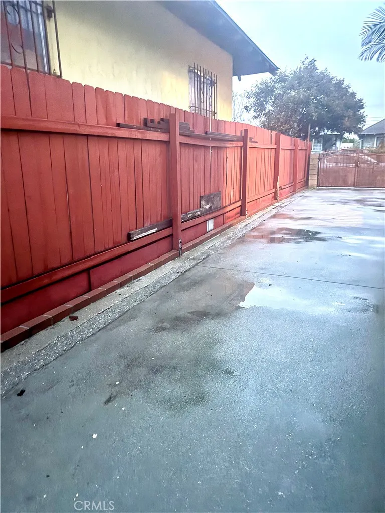 Custom made side to side wood fence  cemented drive way.