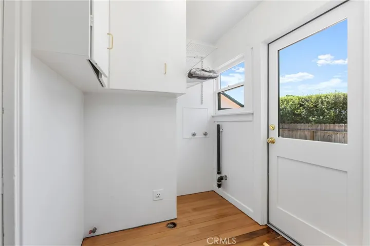 Laundry Room with storage and rear door to side carport.