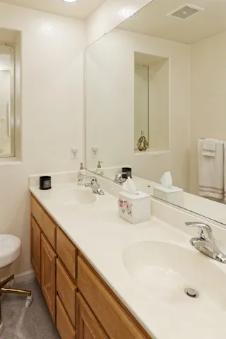 Full bath featuring double vanity and toilet