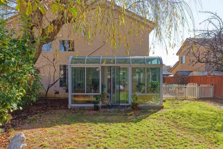 Back of property featuring a sunroom and stucco siding
