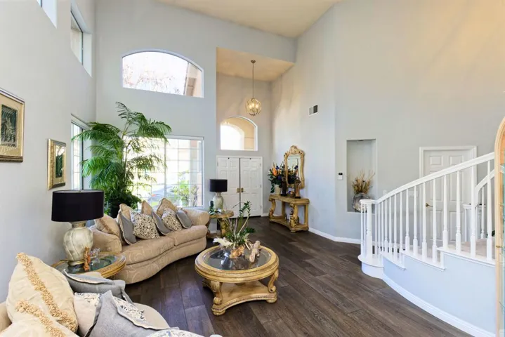 Living room with dark wood-style flooring and a high ceiling