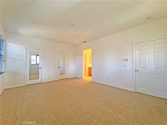 Main bedroom looking towards bathroom and mirrored closet doors