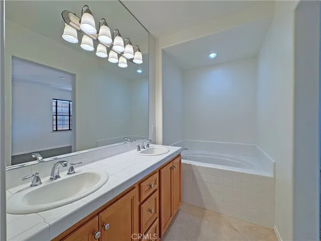 Main bathroom with double sinks and large soaking bathtub for unwinding after a long day
