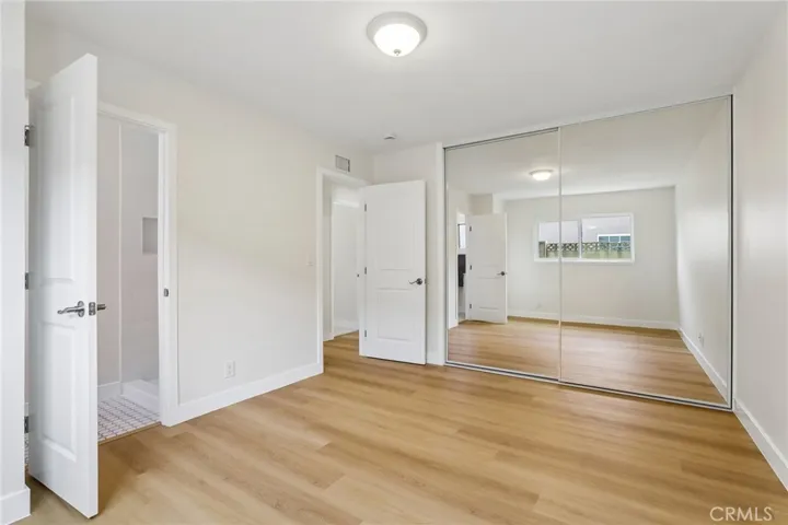 Primary bedroom with the first door on the left to the primary bathroom and the other door to the hall