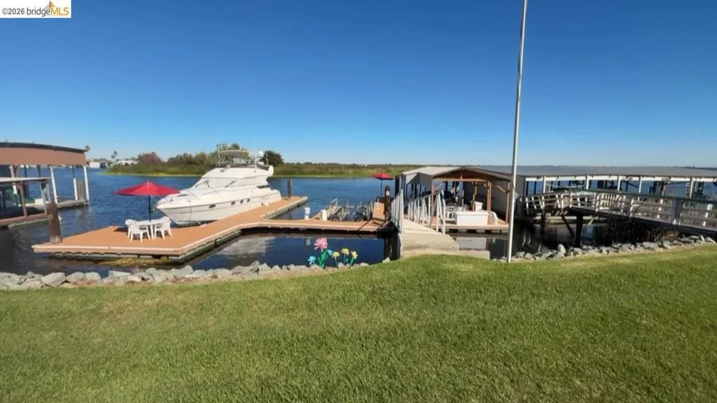 Dock area featuring a water view and a yard