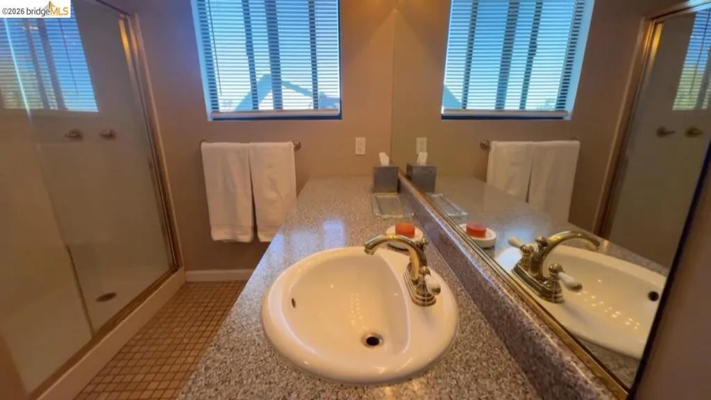 Bathroom with vanity, a stall shower, and light tile patterned flooring
