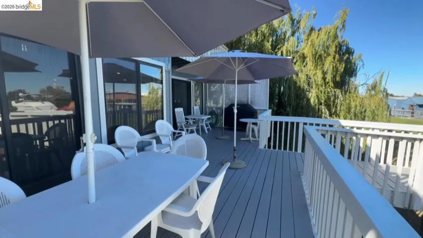 Wooden terrace with outdoor dining space and a grill