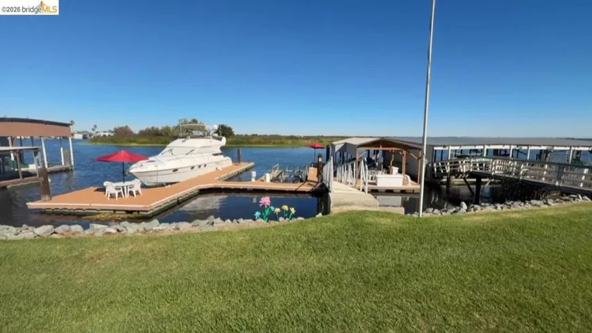Dock area featuring a water view and a yard