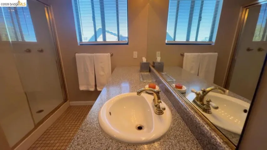Bathroom with vanity, a stall shower, and light tile patterned flooring