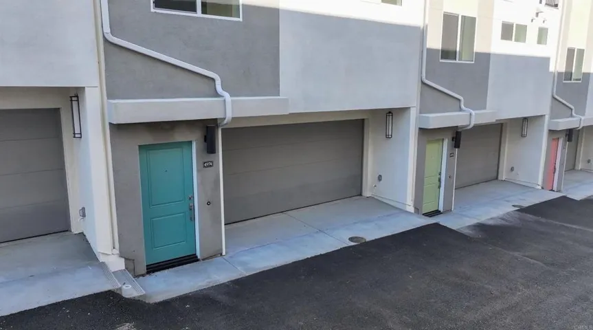 New construction exterior with attached garages in a detached PUD community.