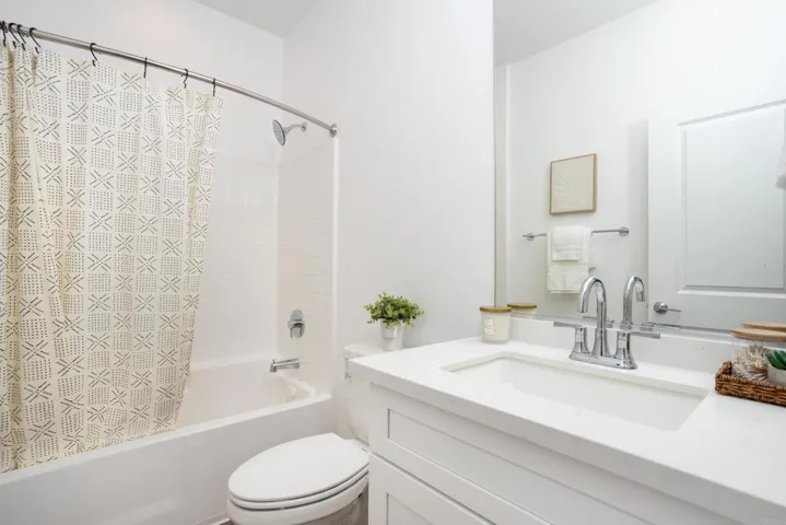 Full hallway bathroom with tub/shower combination and modern vanity.