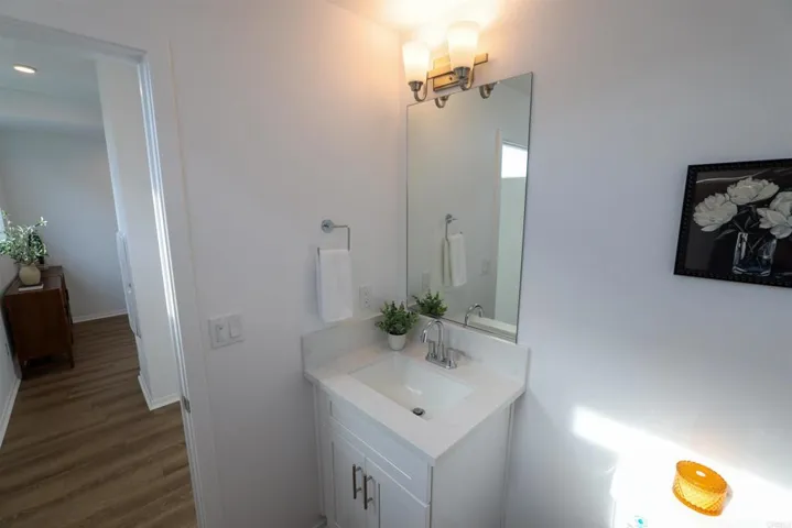 Second-level hallway connecting laundry area and half bathroom.