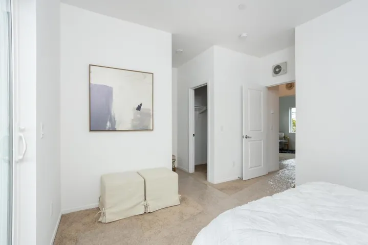 Alternate view of the primary suite showing entry to walk-in closet and bathroom.