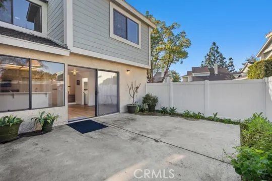 Private backyard surrounded by vinyl fencing with gate.