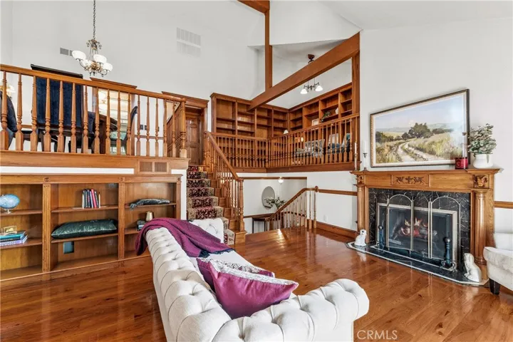 Living room has hickory floor and elegant fireplace. Mezzanine overlooks living room.